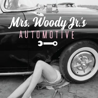 A woman working on a classic car in shorts